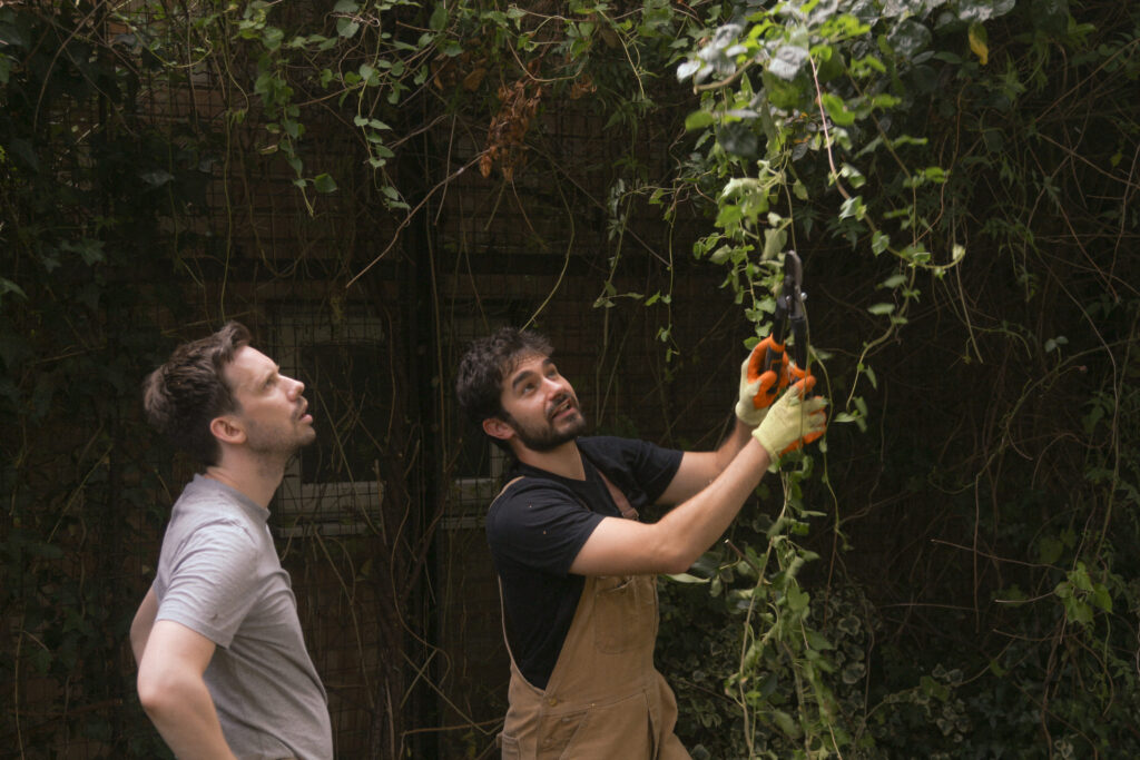 Two 6sense employees help clean up a garden